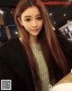 A woman with long brown hair sitting at a table.