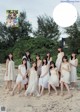 A group of girls in white dresses posing for a picture.