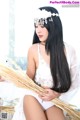 A woman in a white lingerie holding a bunch of wheat.