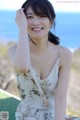 A woman in a floral dress posing for a picture.