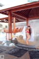 A woman in a pink bikini standing in a hot spring.