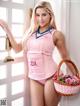 A woman in a pink bathing suit holding a basket of flowers.